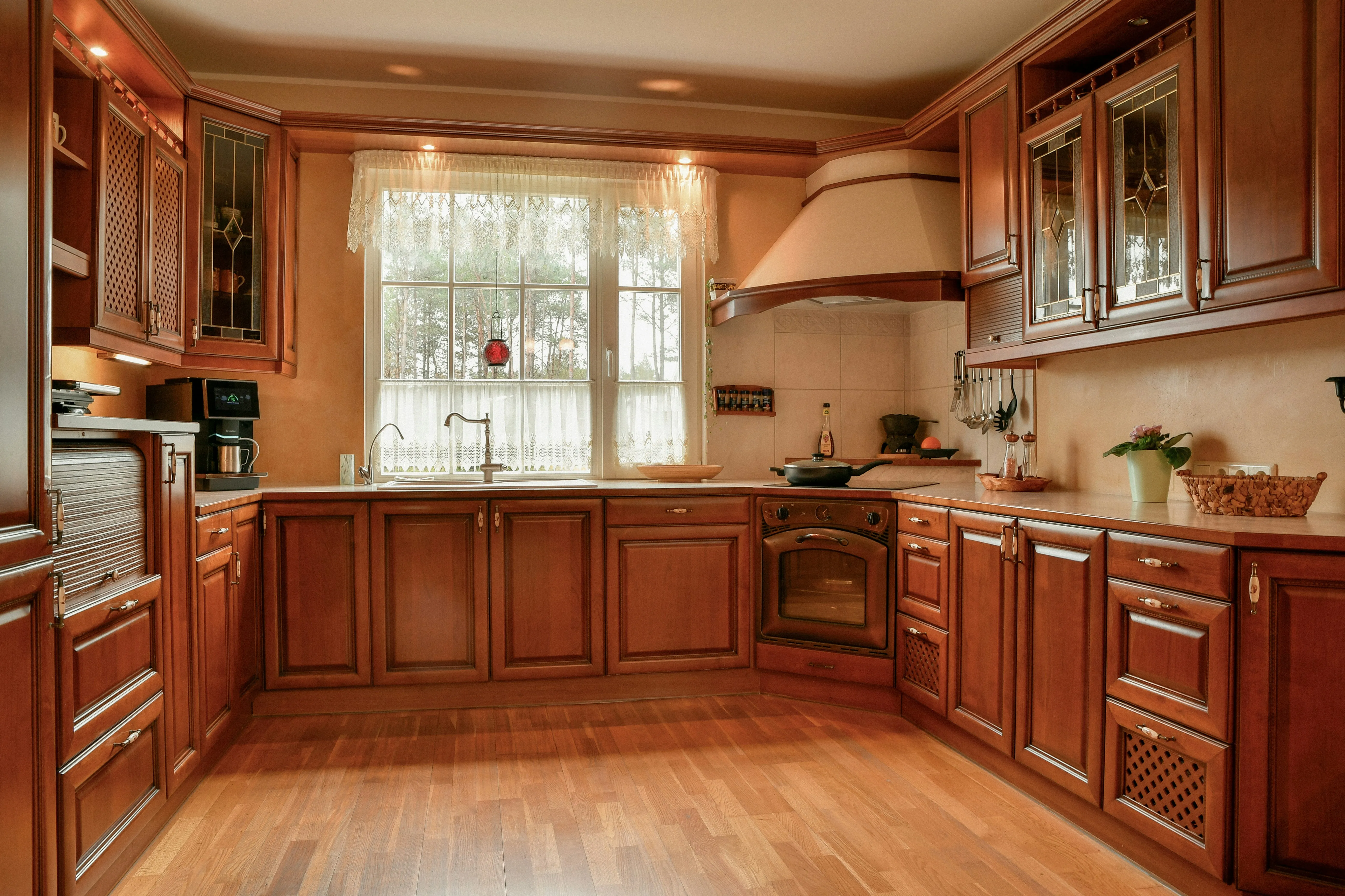 Before: Dated cherry-wood kitchen renovated in the Modern style, same window and layout